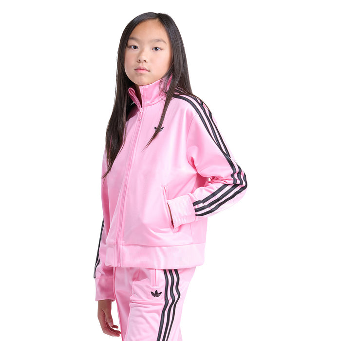 Youth pink track jacket with black sleeve stripes and zip-up front, model side view