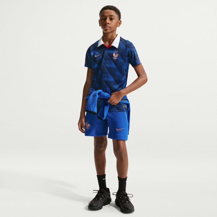 Youth France blue jersey with white collar and red crest, worn with blue shorts