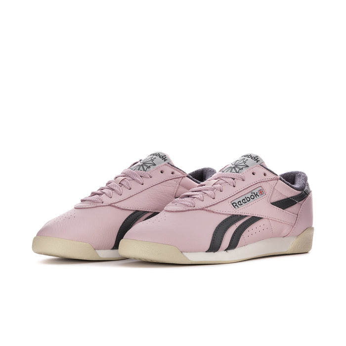 Pair of women's pink lace-up low-top sneakers with black side stripes and cream sole