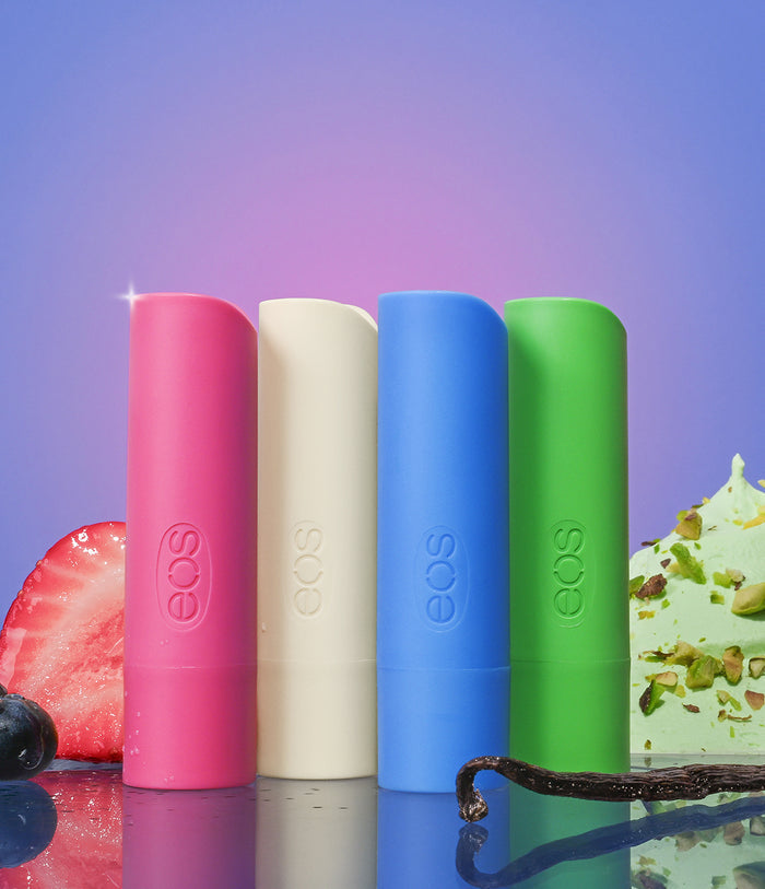 Four colorful EOS lip balm tubes with a dessert background