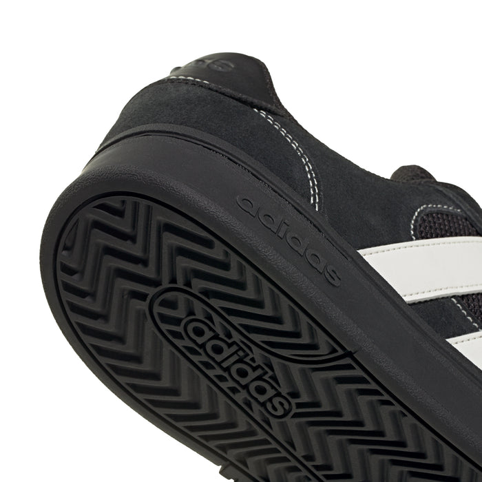 Black outsole with geometric tread pattern and adidas logo near heel