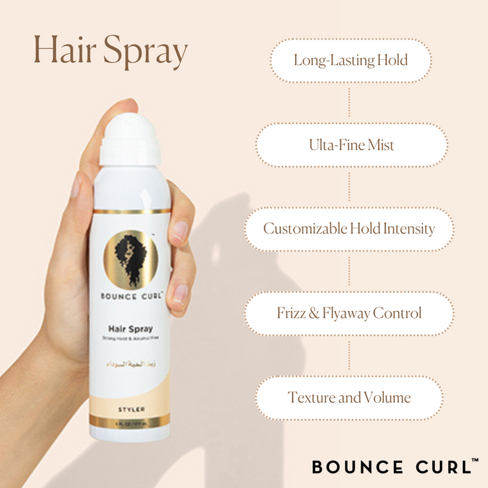 Hand holding Bounce Curl Hair Spray can; long‑lasting, flake‑free hold on peach backdrop.