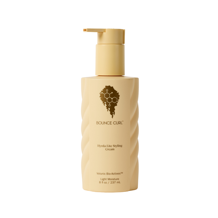Beige bottle with pump of Bounce Curl styling cream on a white background