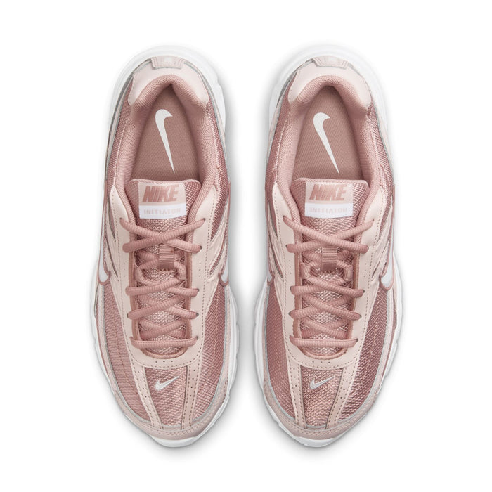 Women's dusty pink sneakers with lace-up front and Nike logo on tongue