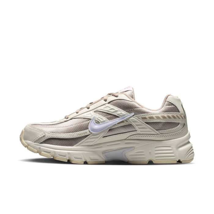 Women's cream and tan lace-up running shoes with swoosh and layered sole