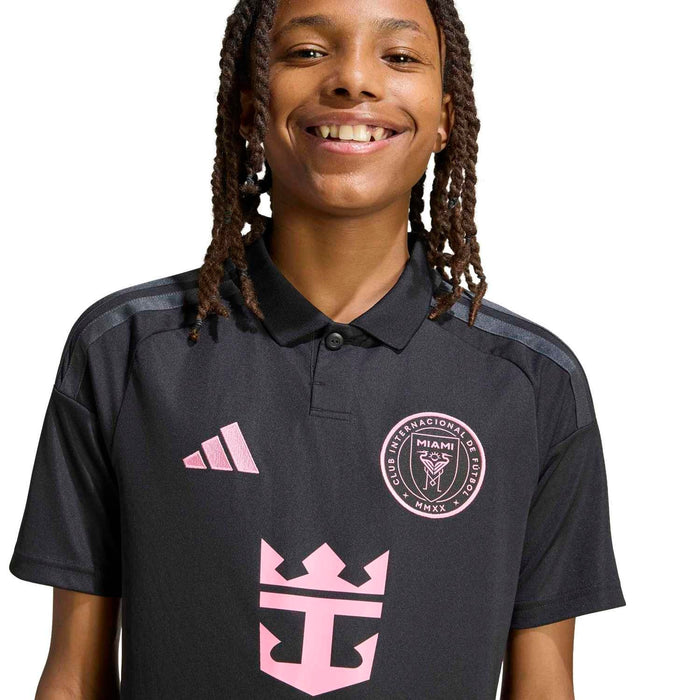 Youth black soccer jersey close-up with pink crest and central front design