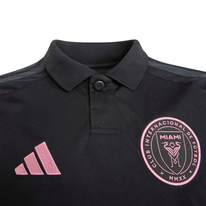 Youth black soccer jersey close-up with button collar and pink crest on chest