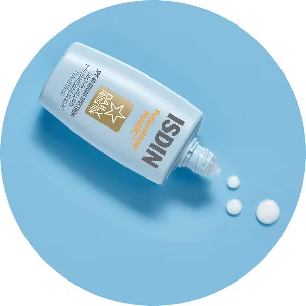 ISDIN Fusion Water MAGIC SPF 40 sunscreen bottle with cream drops on blue background