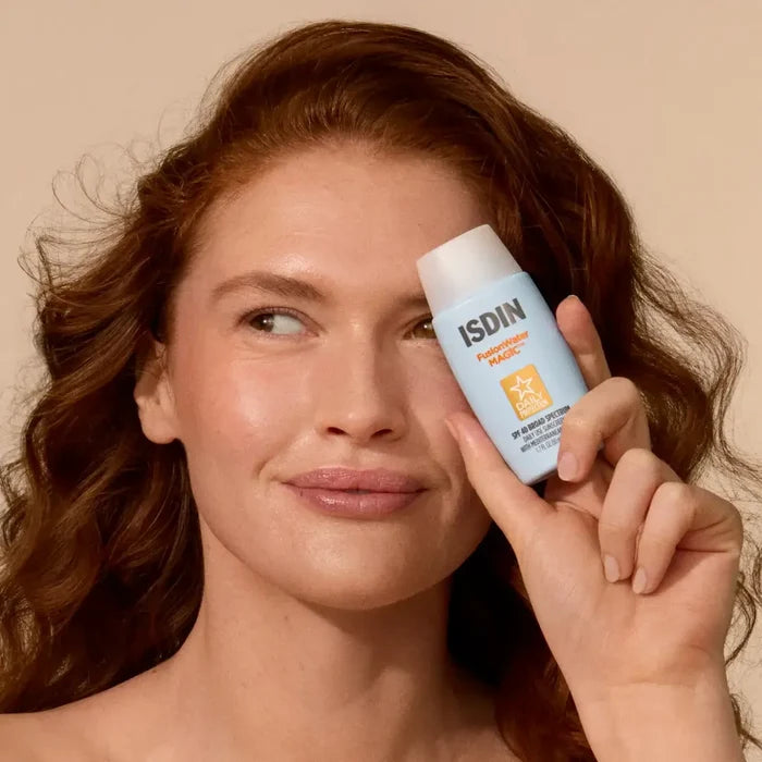 Woman holding ISDIN Fusion Water MAGIC SPF 40 sunscreen bottle