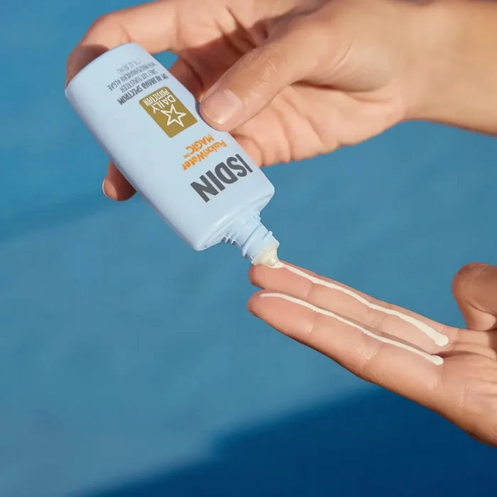ISDIN Fusion Water MAGIC SPF 40 sunscreen lotion being squeezed onto fingers