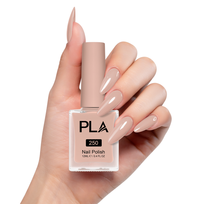 Hand holding a pink nail polish bottle with matching nails on a white background