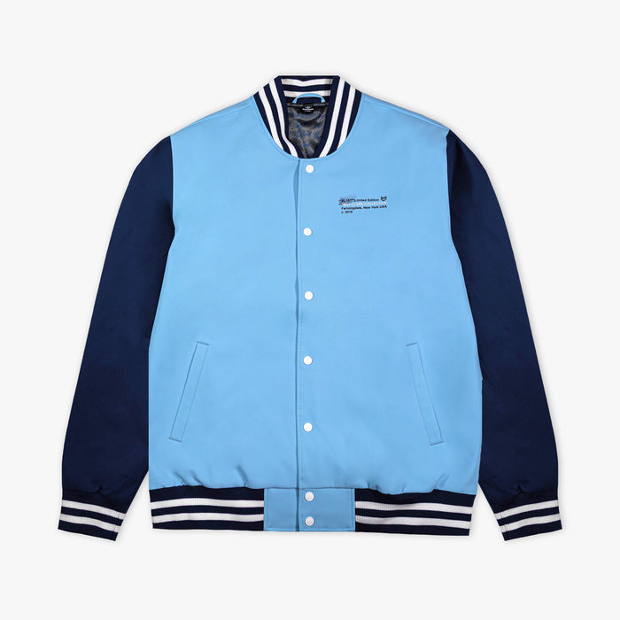 Light blue and navy varsity jacket with white buttons on a light gray background