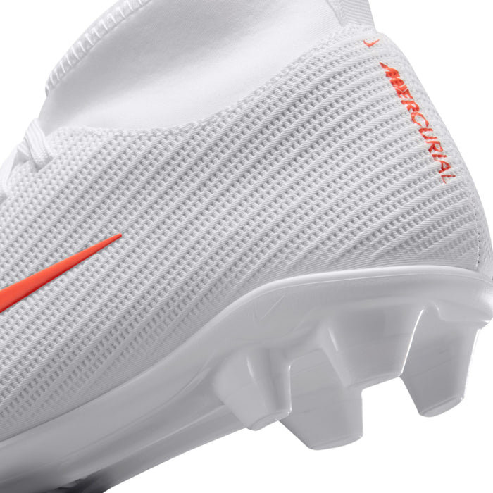 Youth soccer cleats, side close-up, white texture with orange accents and stud sole
