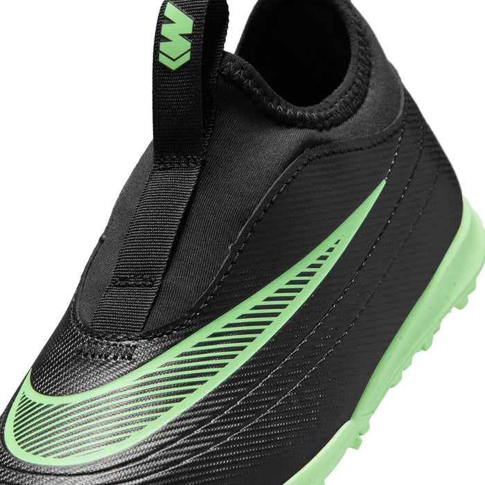 Kids black soccer cleats close-up with green stripe detailing, elastic collar