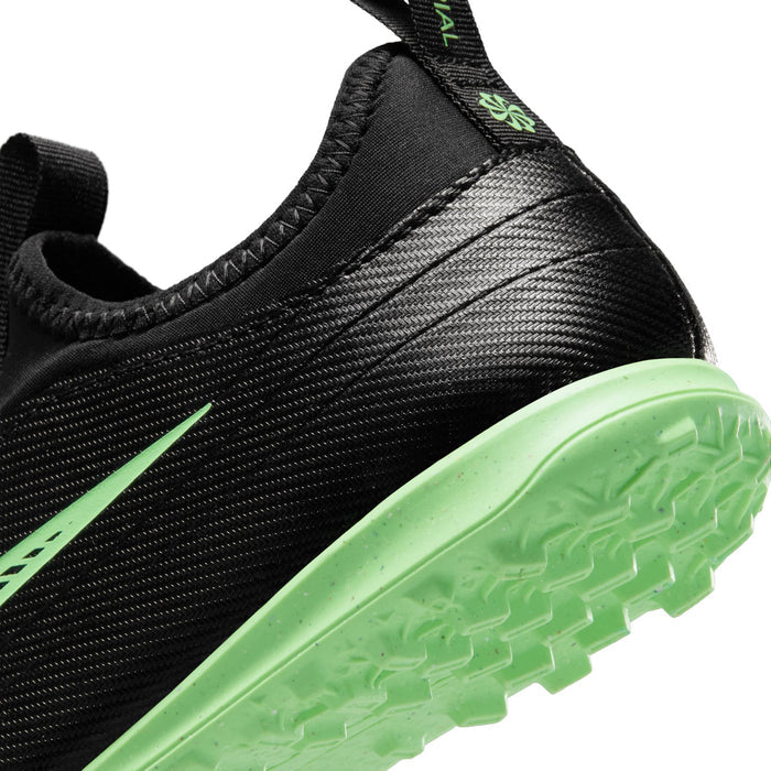 Kids black soccer cleats close-up with green outsole edge and textured upper