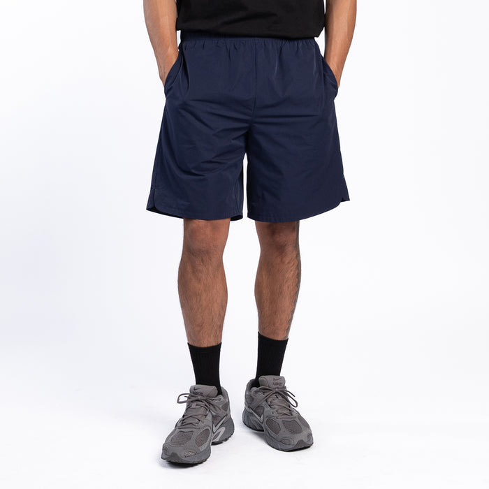 Men's navy woven shorts, rear view, elastic waist and knee-length hem.