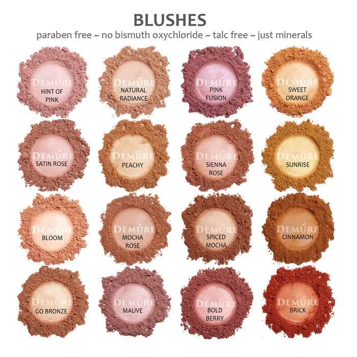 Photo of sample swatches of Demure loose mineral blush shades including hint of pink, satin rose, bloom, go bronze, natural radiance, peachy, mocha rose, mauve, pink fusion, sienna rose, spiced mocha, bold berry, sweet orange, sunrise, cinnamon, and brick.