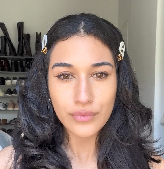 A brunette wearing Demure Face & Body Bronzer