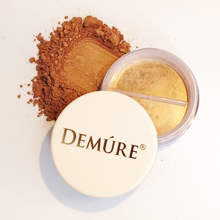 An open jar of Demure Face & Body Bronzer with a swatch on the side