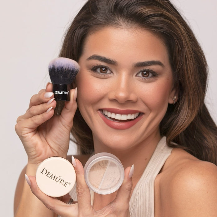 Woman holding Demure Dark Foundation in her hands and  Kabuki Brush