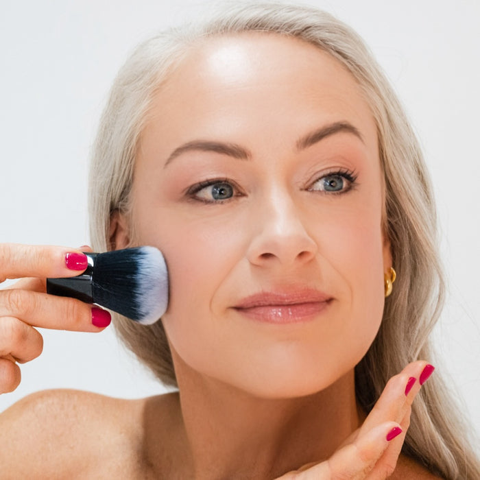 Woman applying Demure Light Foundation with a Kabuki Brush