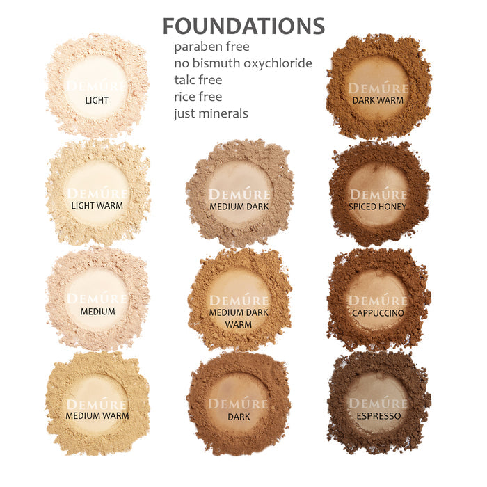 Swatches of Demure loose mineral foundation shades, including light, light warm, medium, medium warm, medium dark, medium dark warm, dark, dark warm, spiced honey, cappuccino, and espresso.
