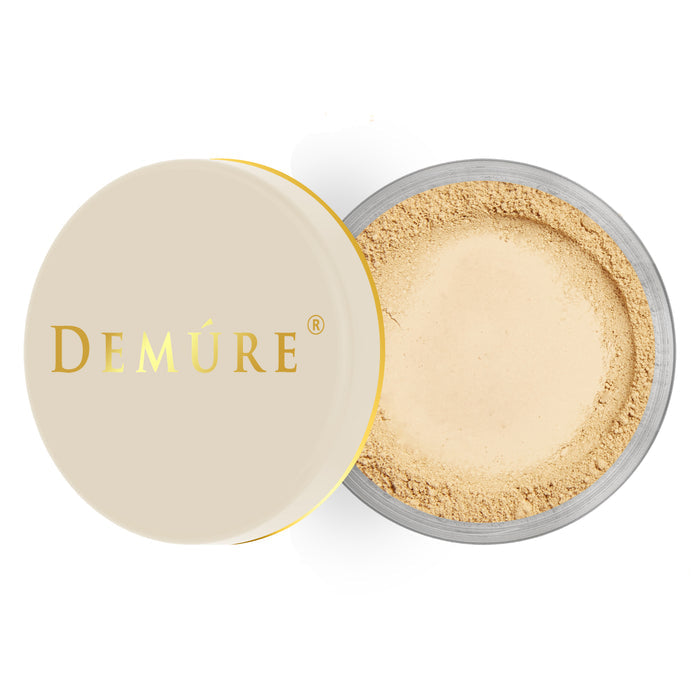 Open container of Demure Medium Warm color loose foundation with a gold lid