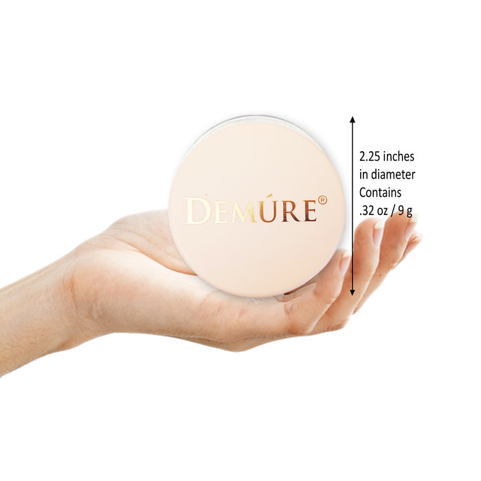 Hand holding a jar of Demure Foundation with the measurements of the jar.