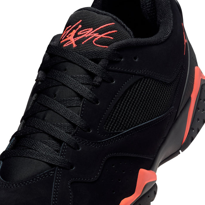 Close-up of black sneakers with red-orange 'Flight' logo on heel, lace-up front