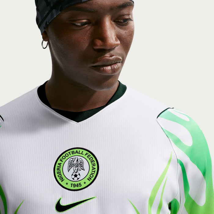 White jersey close-up showing Nigeria Football Federation crest and green-accented Nike swoosh.