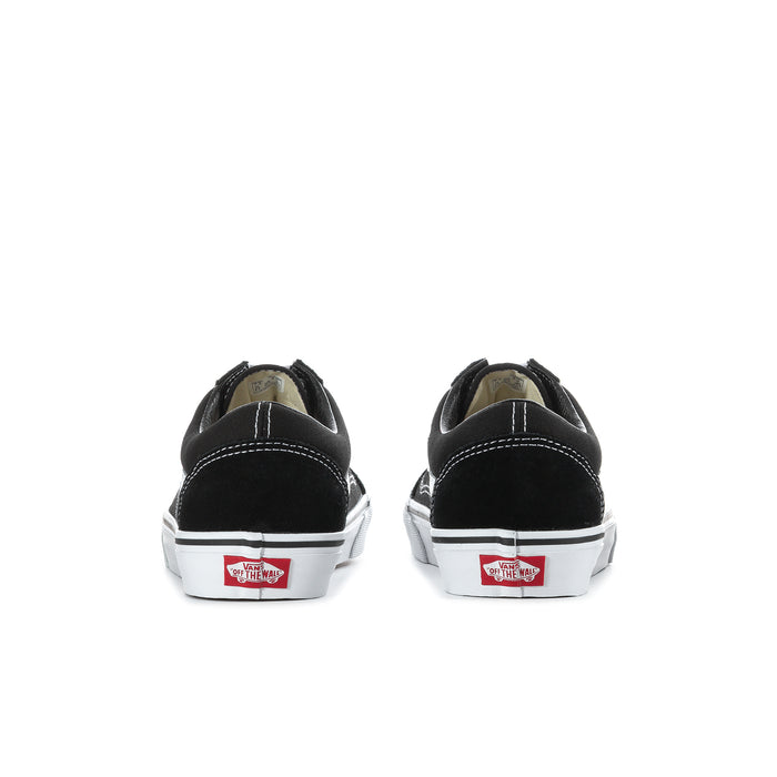 Black sneaker showing white laces, inner label, and tan treaded outsole