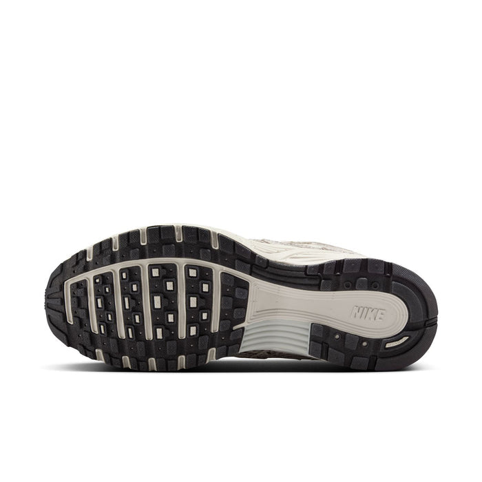Women's Nike sneaker outsole view with black traction lugs and light midsole