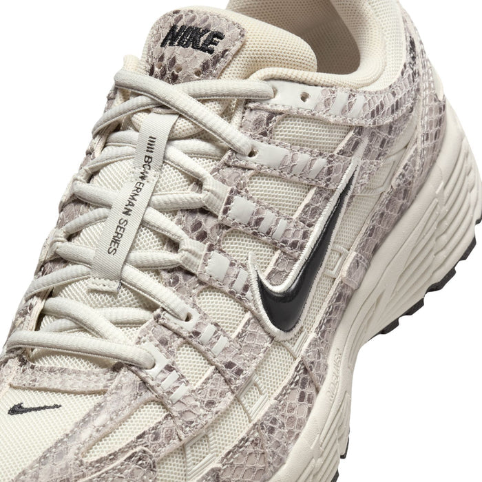 Women's Nike sneaker close-up of laces, light bone and gray snakeskin-patterned upper