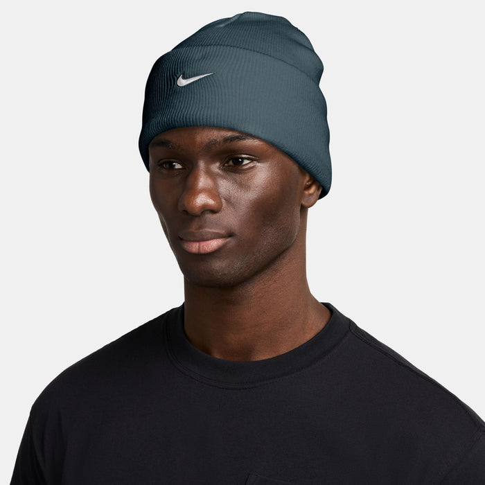 Nike beanie on model, dark teal knit with white Swoosh logo