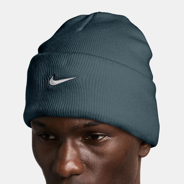 Nike beanie close-up on model, dark teal knit with white Swoosh logo
