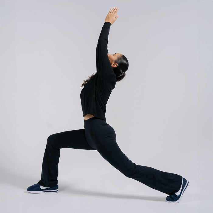 Black flare leggings with bootcut legs and high waist, shown in stretching pose