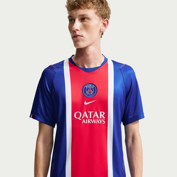 Men's PSG home stadium replica jersey on model, blue with red/white stripe and Qatar Airways