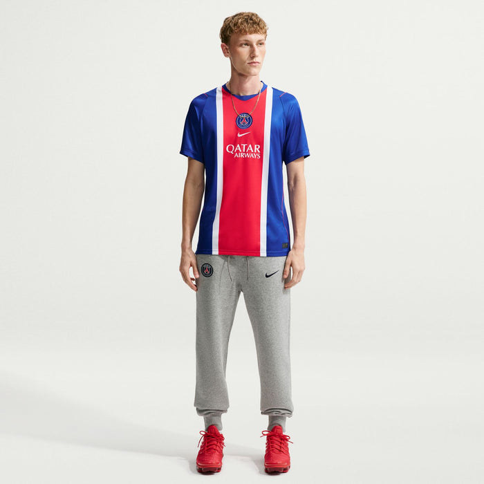 Men's PSG home stadium replica jersey, blue with red/white vertical stripe; worn with gray pants