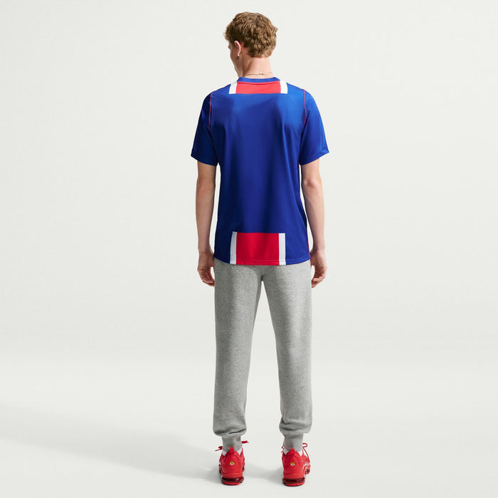 Men's PSG home stadium replica jersey back view, solid blue with red/white stripe hem
