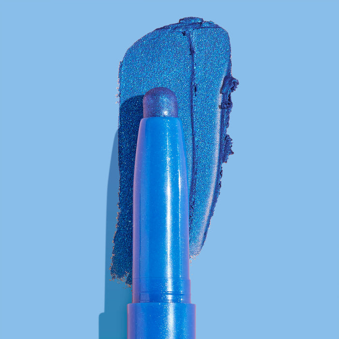 ColourPop Shadow Stix Rain Check shown with a bold metallic cobalt blue swatch behind its twist-up tip on a light blue background, highlighting the shimmer finish and crayon-style eyeshadow stick design.