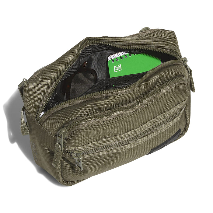 Olive crossbody bag open to show interior pockets and green-lined divider