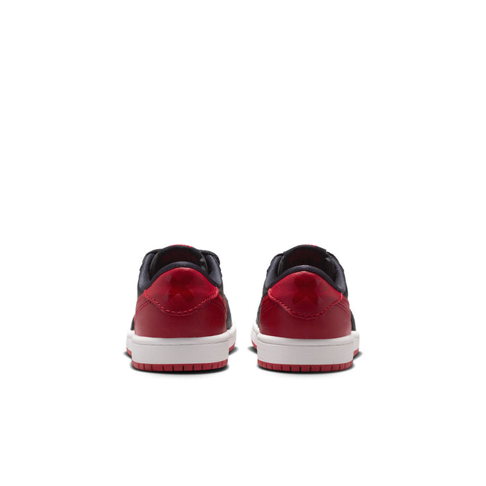 Kids black and red low-top sneakers, rear view with red heel panel and white sole.