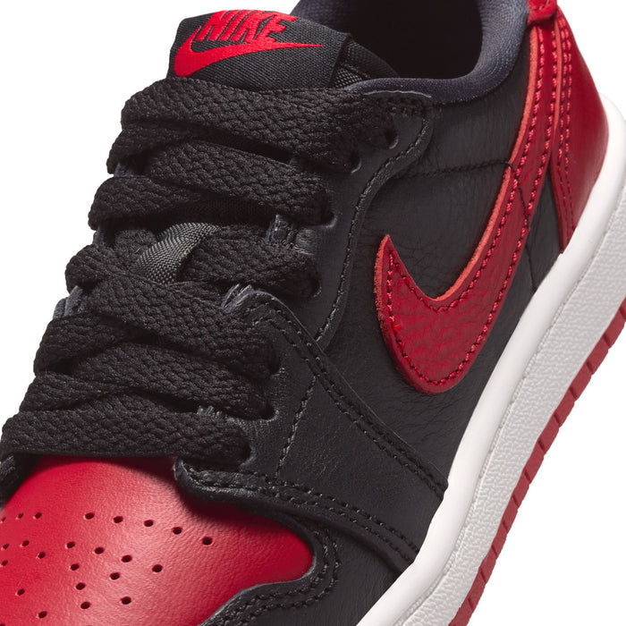 Close-up of kids black and red low-top sneaker upper with red swoosh and laces.