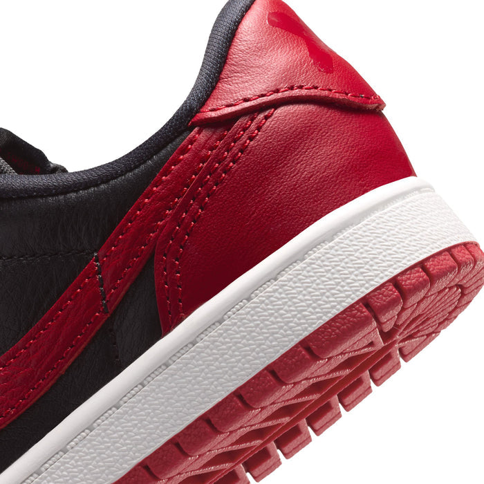 Close-up of kids sneaker side panel with black overlays, red leather, and stitched seams.