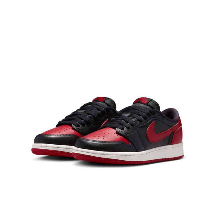 Youth low-top sneakers pair, black uppers with red accents and white soles