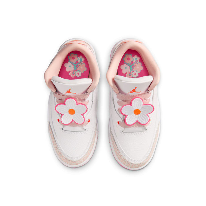 Kids' sneakers: white uppers with pink flower patches and orange center, Jumpman lining.
