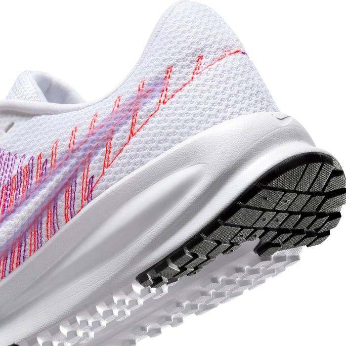 Women’s running shoe toe and sole close-up: white upper with pink/purple stitching, grippy tread.