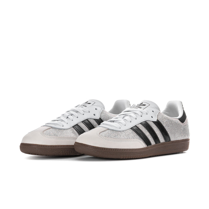 Pair of womens rhinestone low-top sneakers in white with black adidas stripes