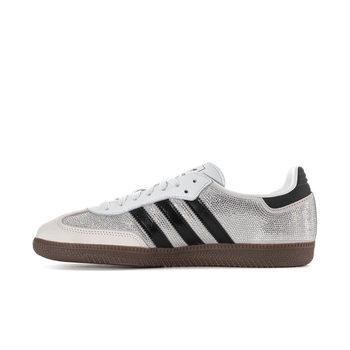 Side view of white rhinestone sneakers with black adidas stripes and gum sole