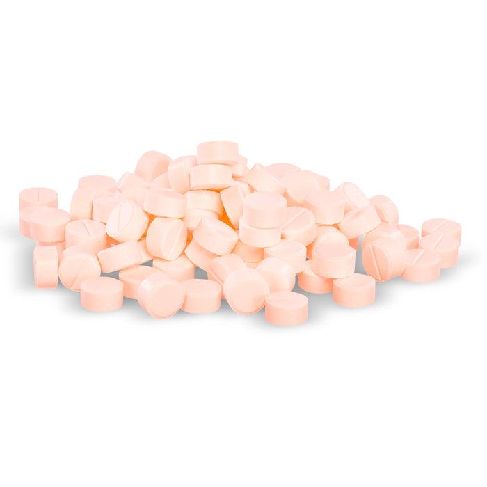 Many pale pink pills are piled loosely together on a white background.